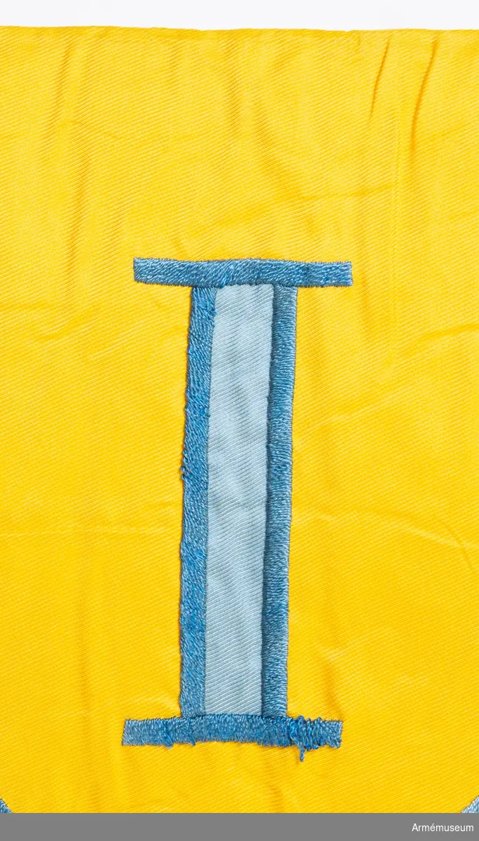 Kommandotecken för Södra militärområdet (ursprungligen Första militärområdet), i gult siden med applikation i blått siden med broderi i blått silkegarn.
På gul botten två blå korslagda svärd under den romerska siffran 1. Vit stång med kannelyrer och spets av mässing.