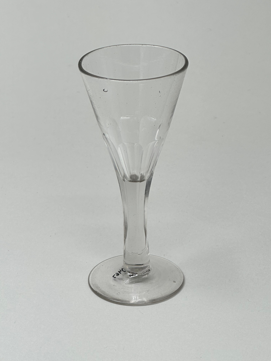 Snapsglas på fot, pelarslipning. Konformad kuppa.
