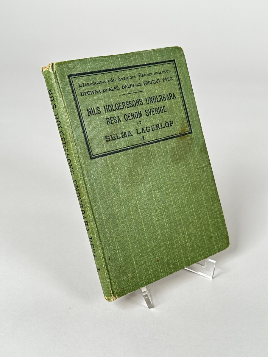 Bok, inbunden i grönt klotband, med titeln tryckt i svart på frampärmen: LÄSEBÖCKER FÖR SVERIGES BARNDOMSSKOLOR UTGIVNA AV ALFR. DALIN OCH FRIDTJUV BERG - NILS HOLGERSSONS UNDERBARA RESA GENOM SVERIGE AV SELMA LAGERLÖF I. På försättsbladet skrivet med bläck: Folke Kjellstrand. 265 sidor, med ett antal illustrationer. 
Boken är avsedd som bredvidläsningslitteratur, en slags reseberättelse om Sverige för barn.