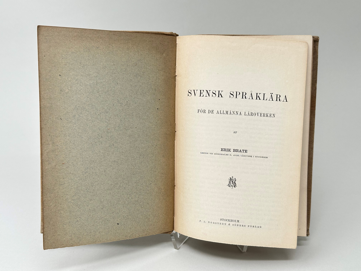 Lärobok, bunden i kartongband, klätt med grå klot. Titel och författare tryckt i svart på frampärmen: Erik Brate Svensk språklära. 235 sidor. Priset tryckt på framsidan: 2 kronor.