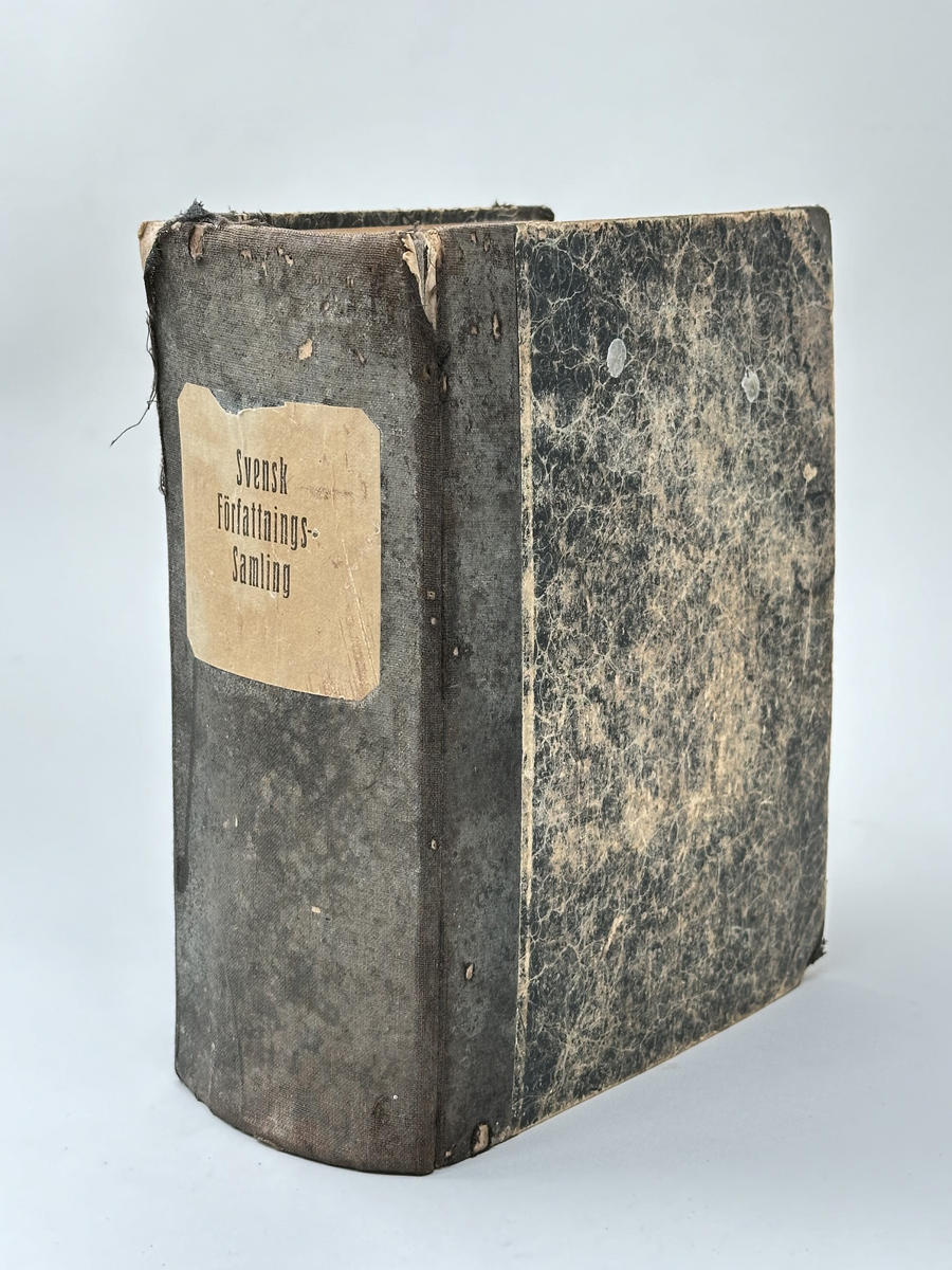 Bok "Svensk Författningssamling" för 1913. Rygg i textil, omslag i marmorerad kartong. Bokens titel på brun etikett på bokens rygg. 