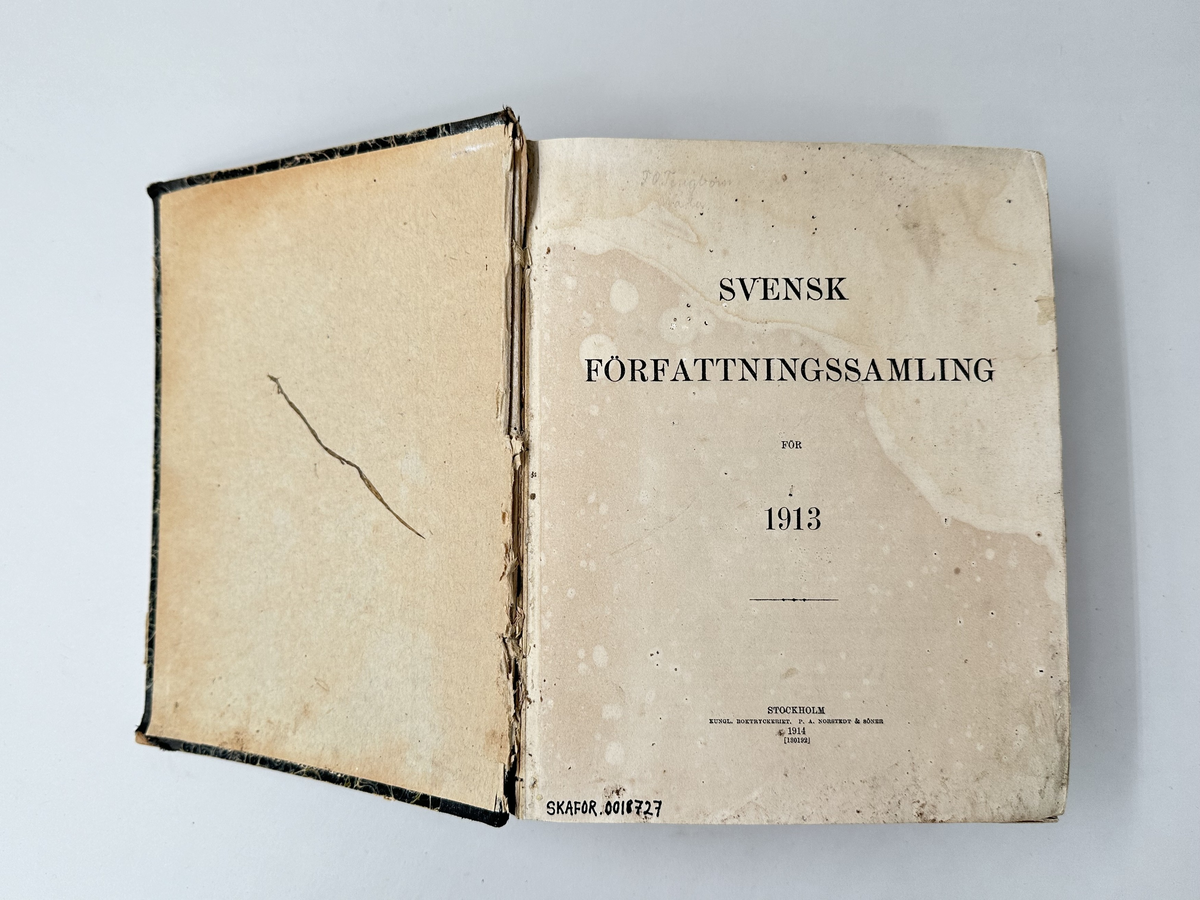 Bok "Svensk Författningssamling" för 1913. Rygg i textil, omslag i marmorerad kartong. Bokens titel på brun etikett på bokens rygg. 