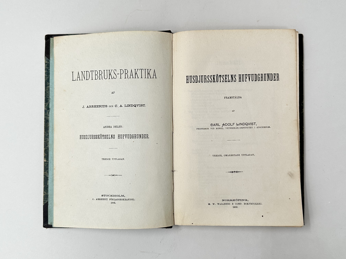 Bok: "Landtbruks-praktika". Rygg samt omslagets hörn i skinn. Omslaget i grön, marmorerad kartong. Röda marmoreringar på bladens utsida. Titelns namn i guldfärgad text. Samlingsnumrering Väla Sockenbibliotek Nr 361.