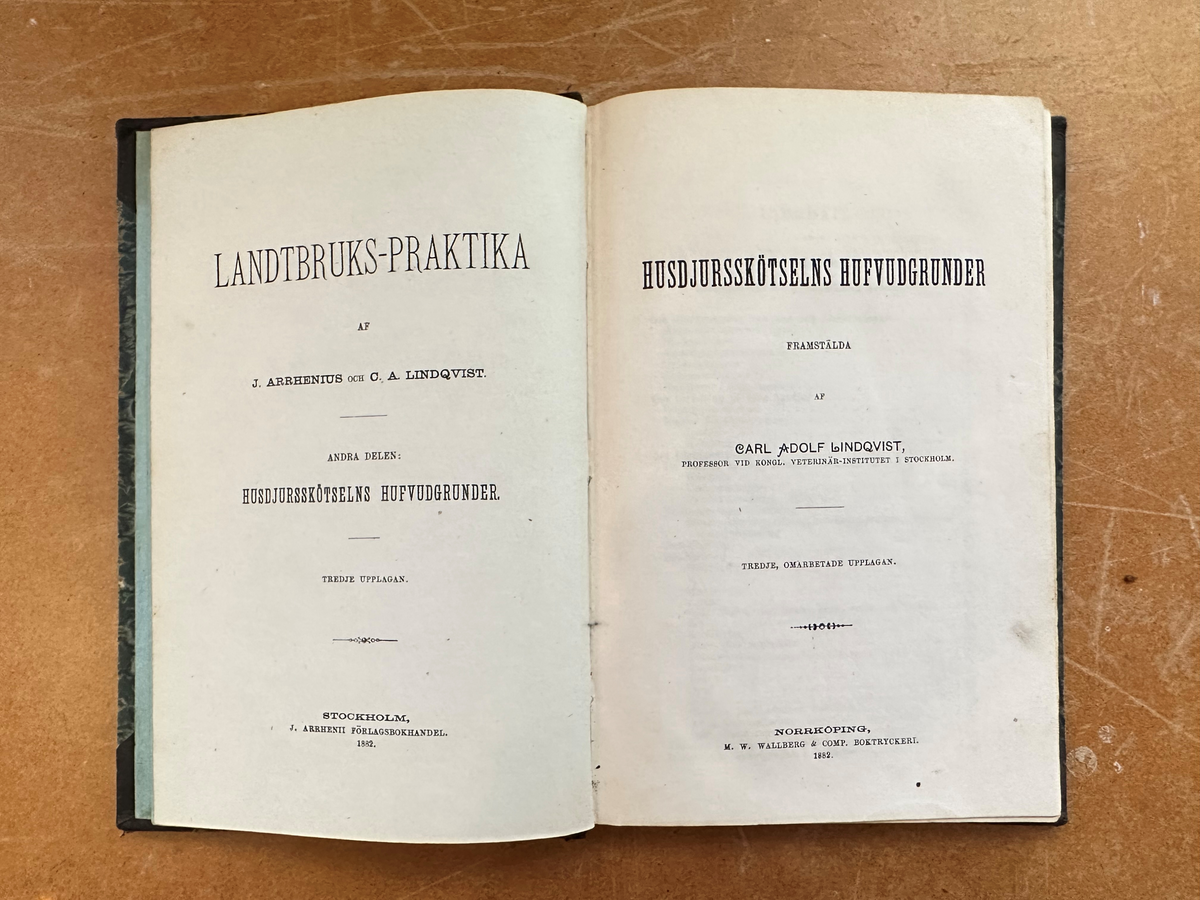 Bok: "Landtbruks-praktika". Rygg samt omslagets hörn i skinn. Omslaget i grön, marmorerad kartong. Röda marmoreringar på bladens utsida. Titelns namn i guldfärgad text. Samlingsnumrering Väla Sockenbibliotek Nr 361.