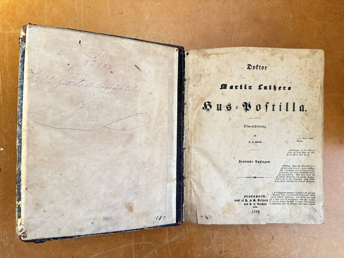 Bok: "Doktor Martin Luthers Hus-Postilla". Utgiven 1872 i Stockholm.
Rygg av mörkt läder med klisteretikett i papper upptill. Pärm av kartong, illa medfaren
Samlingsnumrering Väla sockenbibliotek Nr 197.