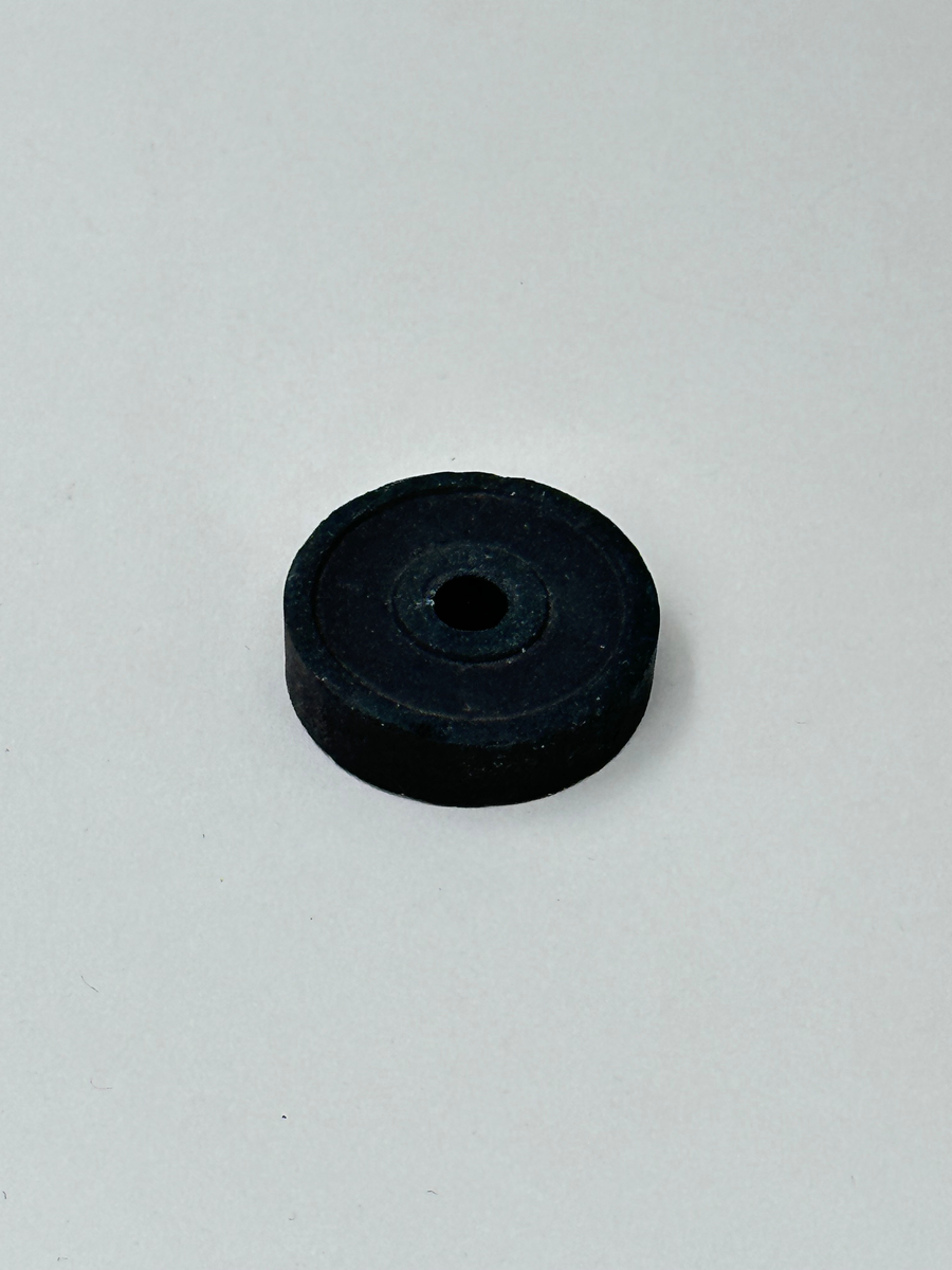 Lösa delar till symaskin, 19 till antalet. Bland annat pressarfötter, en svart ring med hål i mitten samt diverse andra platta metalldelar. 