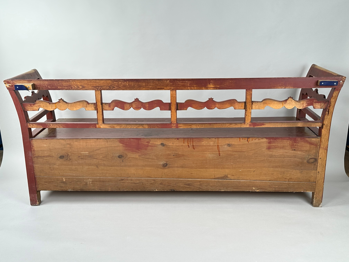 Kökssoffa i gran. Rödmålad. Rak rygg delad i fyra sektioner med en vågig tvärbricka mellan varje sektion. Armstöden något utåtsvängda med motsvarande tvärbricka. Fyrkantiga låga ben. Lock bestående av två brädor, avtagbart. Soffan ursprungligen utdragbar, senare fastskruvad i infällt läge. Insidan obehandlad. Senare förstärkt invändigt med en obehandlad bräda skruvad i soffans bakkant. Den utdragbara delen har två låga ben i framkant.