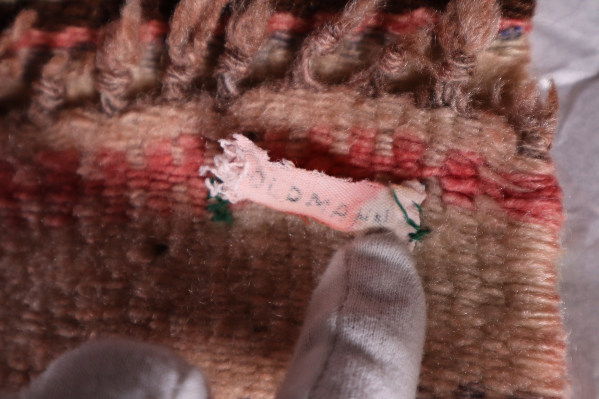 Stripete teppe med frynser i hver langende.