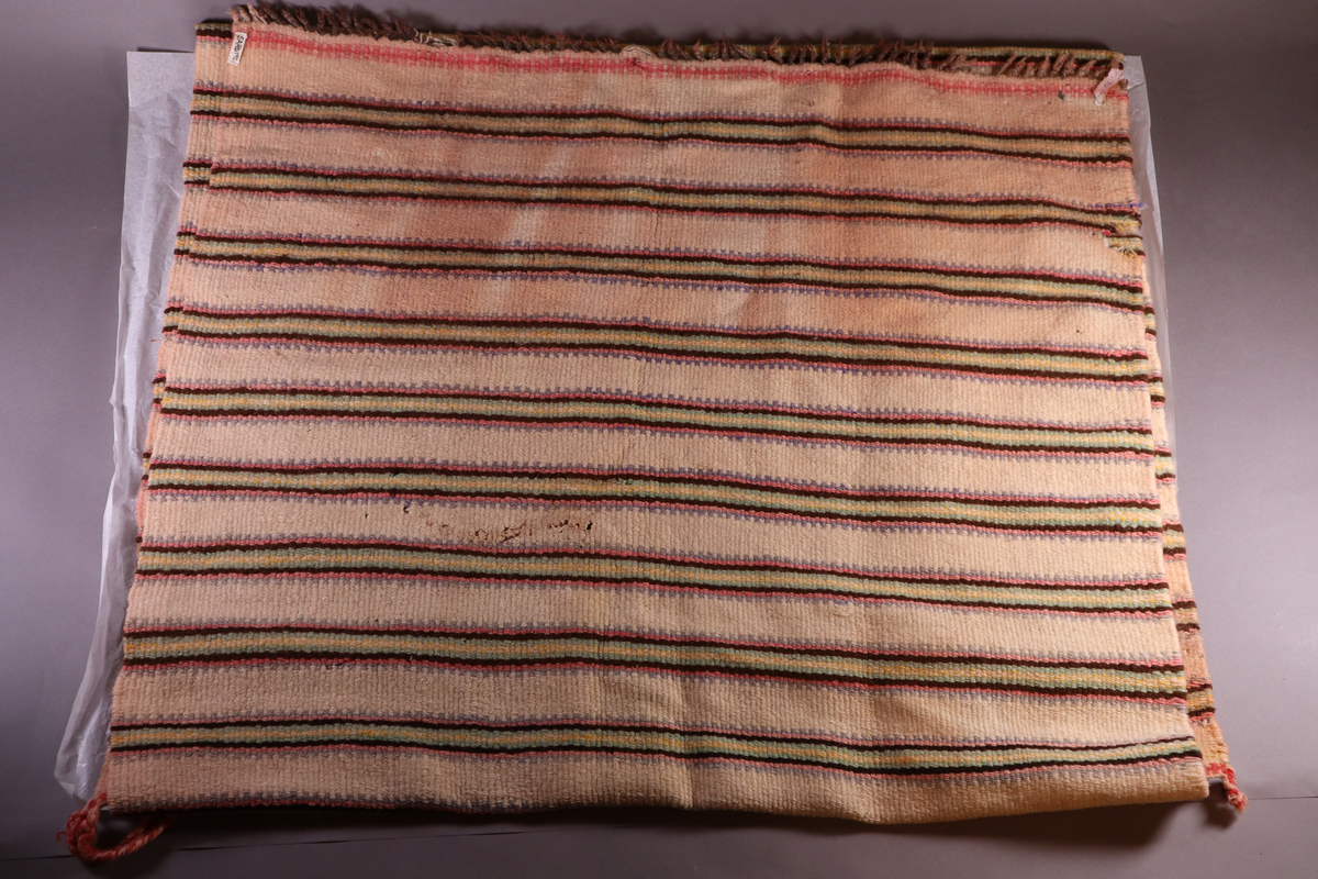 Stripete teppe med frynser i hver langende.