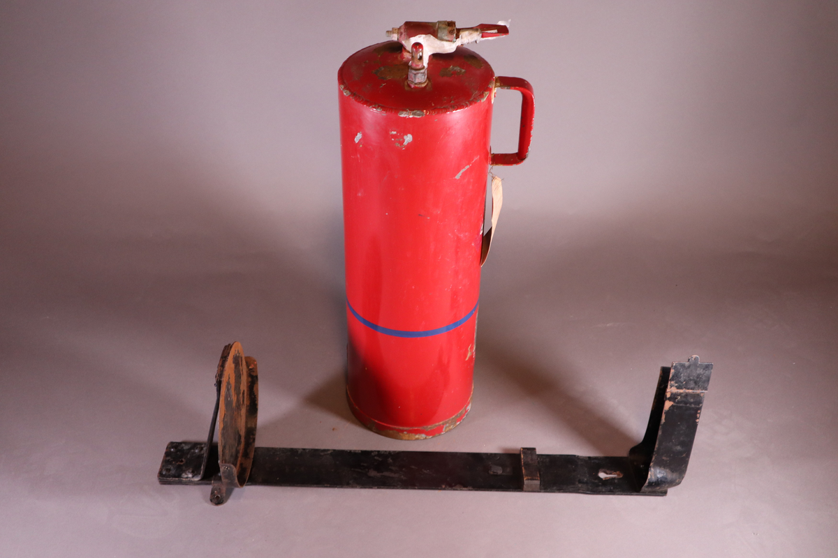 Brannslukningsapparat med veggfeste. Håndtak nesten helt oppe på ene siden.