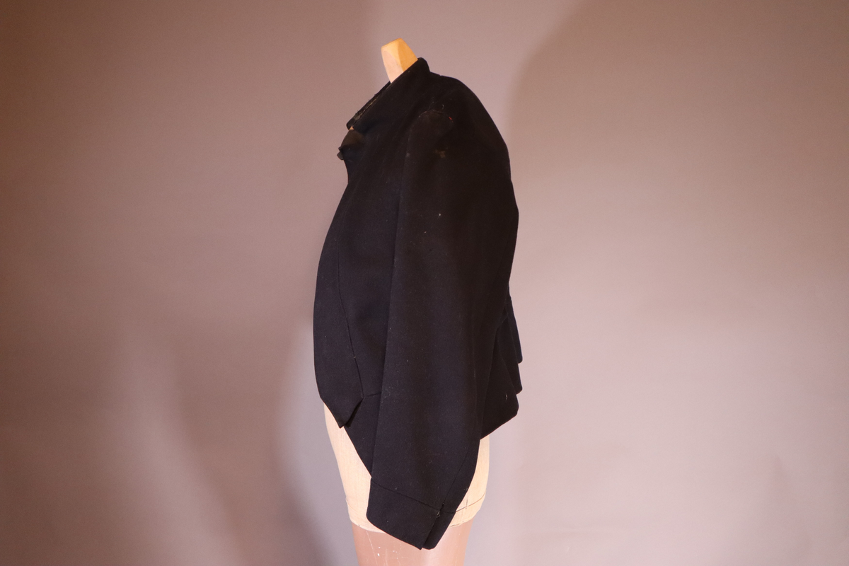 Fangejakke med påsydd lapp med fangenummer og bokstav.