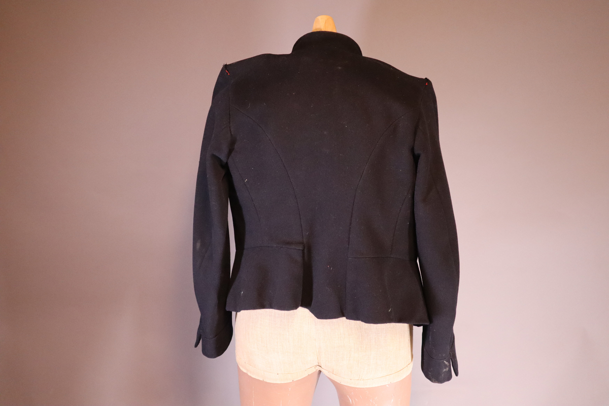 Fangejakke med påsydd lapp med fangenummer og bokstav.