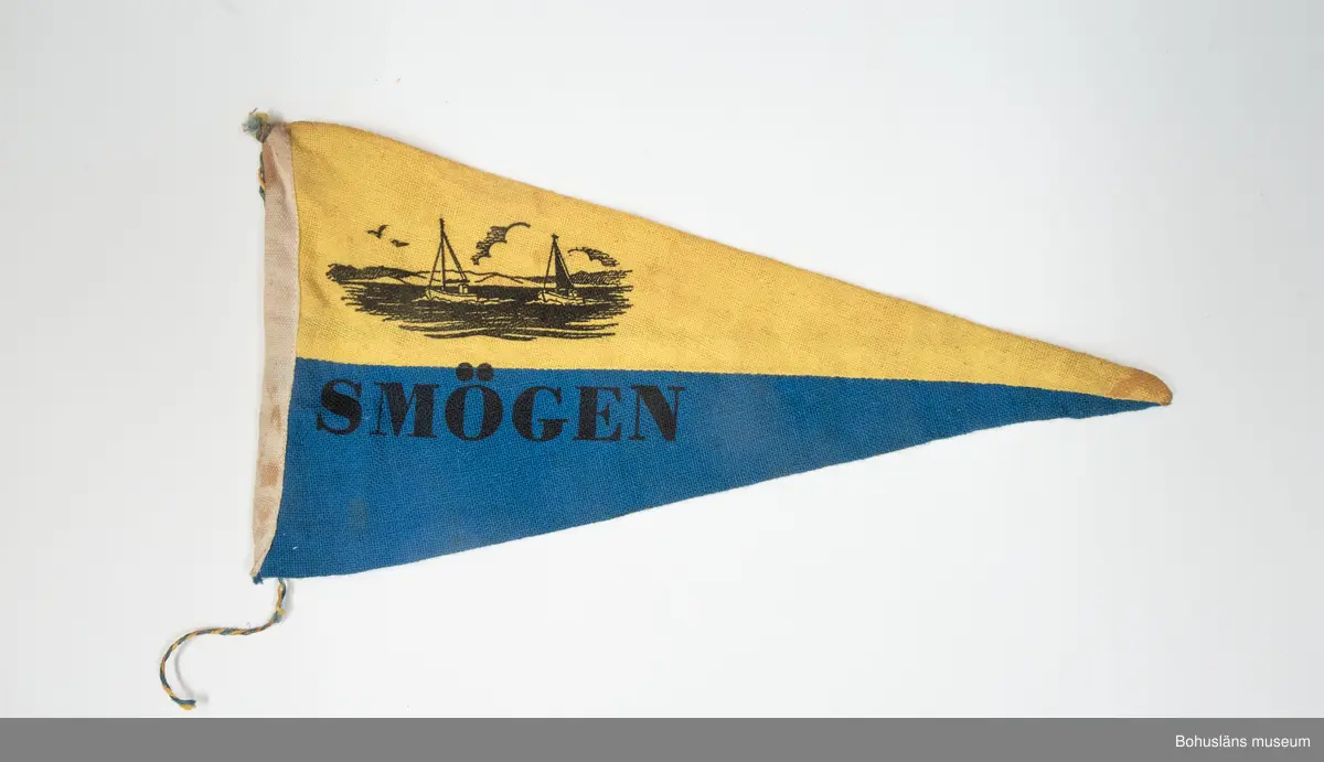 Fem vimplar (UM026180-UM026184) inköpta på semesterresa i Bohuslän 1960 då brukaren var 15 år. Han bodde med sina föräldrar i Stockholmstrakten där fadern var egen företagare med målerifirma. Att första semesterresan gick till Bohuslän  berodde till stor del på att fadern lärt känna en målarmästare från Uddevalla på en förgyllarkurs i Stockholm. Familjen skaffade 1957 en bil - Volkswagenbuss - som under veckorna användes i faderns firma och på helgerna med omgjord inredning av familjen för söndagsutflykter i Mälardalen.
Vid tiden för resan till Bohuslän var brukaren 15 år och arbetade som målarlärling och köpte vimplarna för egna intjänade pengar.
Vimplarna sattes fast på cykeln på snöre fäst nedtill på framgaffeln och andra ändan på styret,ett snöre på vardera sidan med där fastknutna vimplar som då fladdrade fint i fartvinden. Det var vanligt att  pojkarna tävlade att ha de mest ovanliga vimplarna med namn på olika platser (främst i Sverige), som verkade nästan exotiska. Cykelmotorcross var en vanliga företeelse. Brukaren bytte efter en kort tid cykeln mot NV-autoped (tidig mopedsort från Nymanverkstäderna i Uppsala). Vimplarna flyttades över till denna. Vimplar kunde även vara placerade bakom sitsen - "limpan" - på mopederna.
Den 12 augusti 1961 körde han in i sidan på en bil med sin trimmade autoped och skadades svårt. Efter denna dag har han ej använt vimplarna.
Flera av hans kamrater hade sådana vimplar uppsatta på väggarna i sina pojkrum, vilket brukaren aldrig haft.

Tresidig vimpel med ett övre gult och ett undre blått fält. Havsmotiv med fiskebåtar och namnet "Smögen" i svart textiltryck.