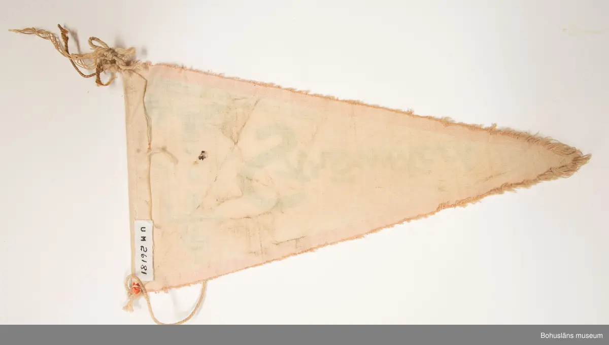 Trekantig vimpel. Naturfärgad bomull med textiltryck. Röd kant och i grönt bild av Strömstads kyrka och namnet "Strömstad".
Sammanhör med UM026180 - UM026184.
Användar- och förvärvsuppgifter se UM026180