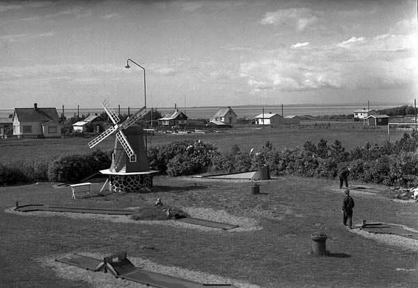 Utsikt från kiosktaket över Skummeslövsstrand. Minigolfbana med spelande människor. Fritidsbebyggelse och havet i bakgrunden.