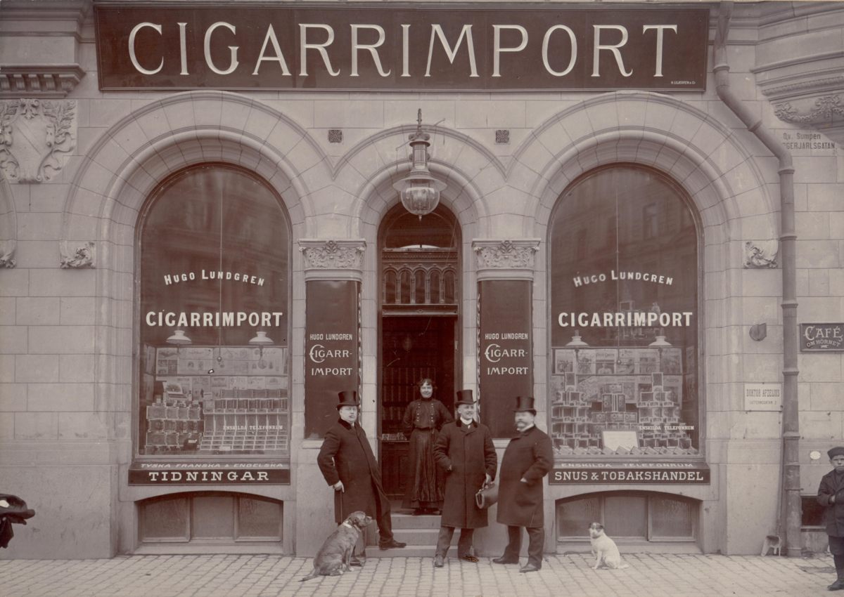 Butiksägare och personal står framför butiken Hugo Lundgrens Cigarrimport på Birger jarlsgatan, tidigt 1900-tal.
