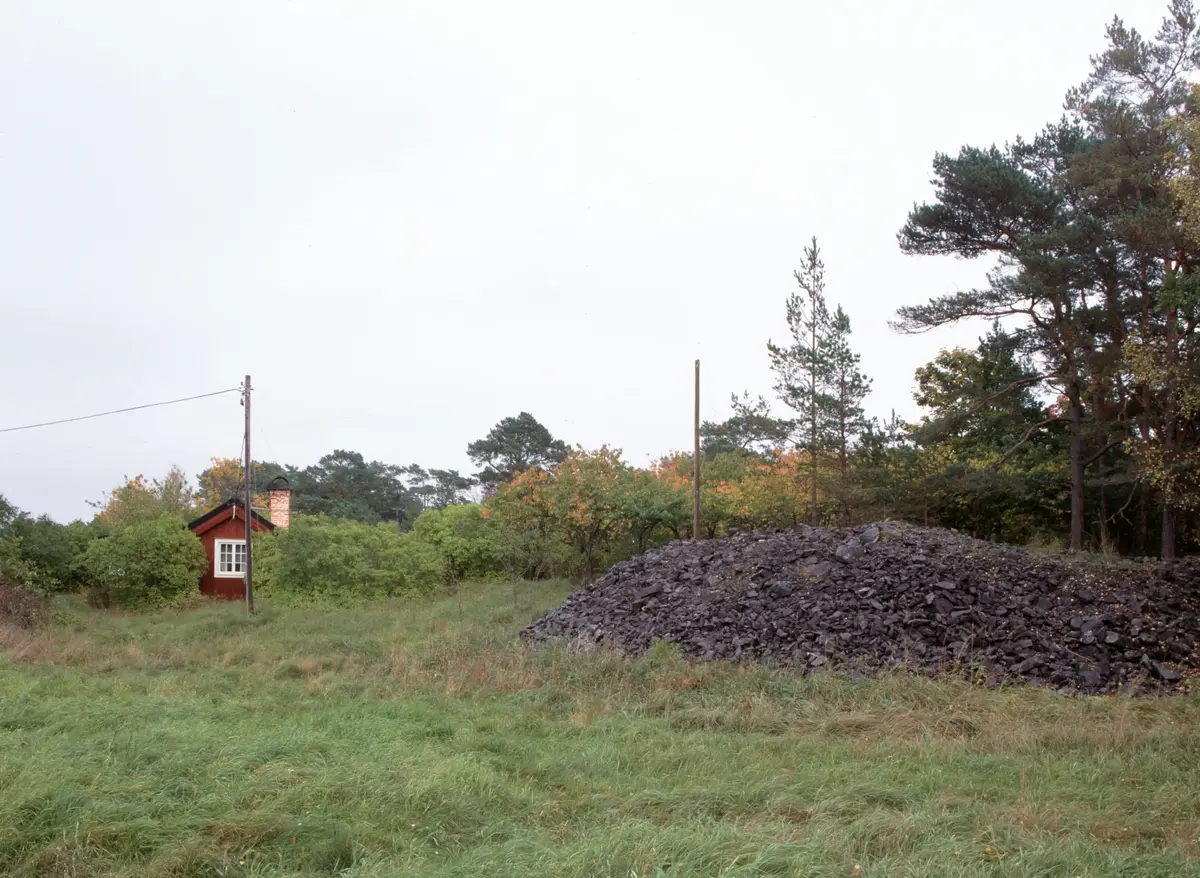 Slaggvarp med ett av husen väster om Nyköpingsgruvan.