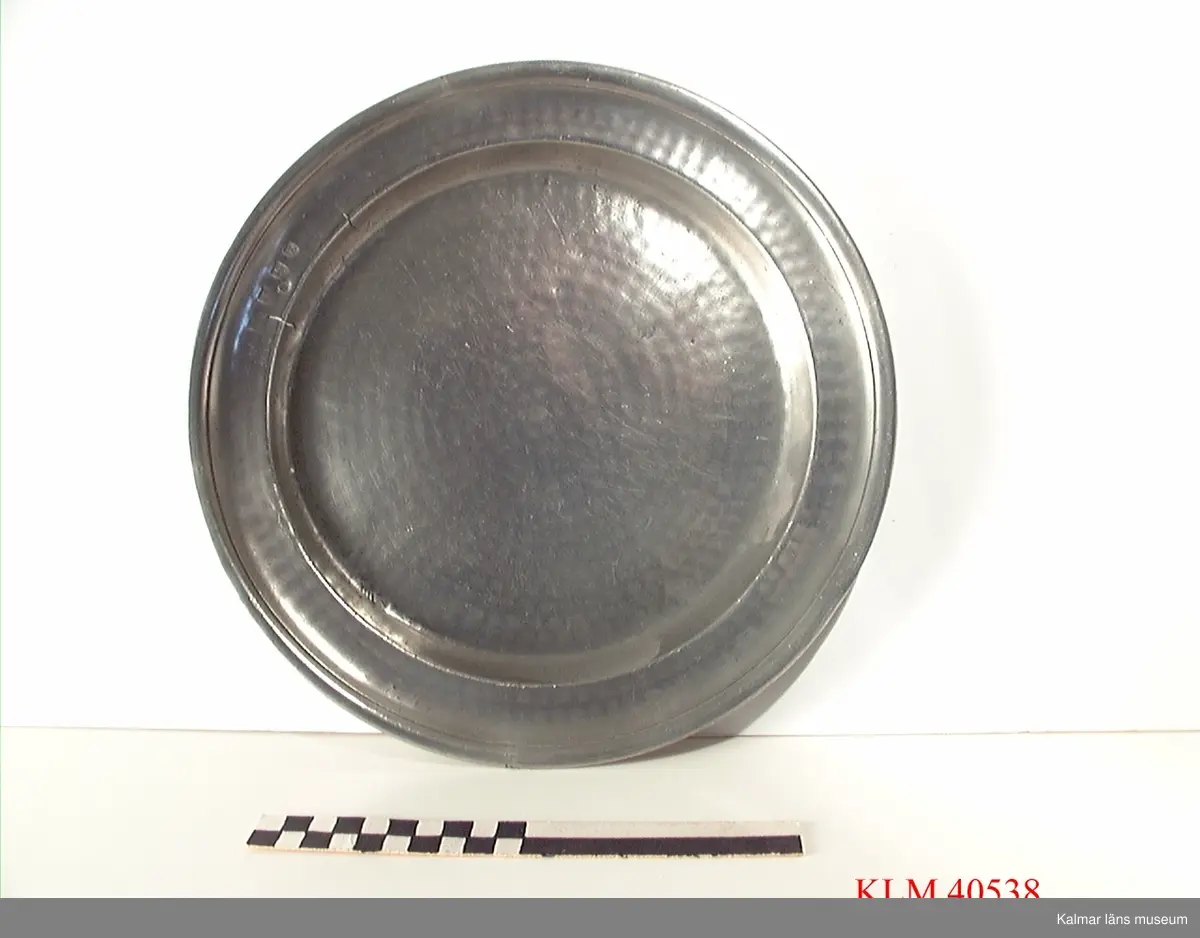 KLM 40538 Fat, tenn, runt. Stämplar på framsidan: I/J?, D, S, 0 samt en sköld med bila, krona och något mer. Stämplar på baksidan: Norrköping samt en sköld med krona (stämpel oläslig). Ristade initialer: IHS eller dylikt.