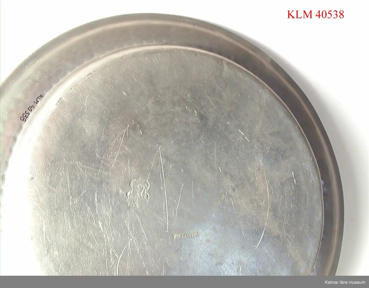 KLM 40538 Fat, tenn, runt. Stämplar på framsidan: I/J?, D, S, 0 samt en sköld med bila, krona och något mer. Stämplar på baksidan: Norrköping samt en sköld med krona (stämpel oläslig). Ristade initialer: IHS eller dylikt.