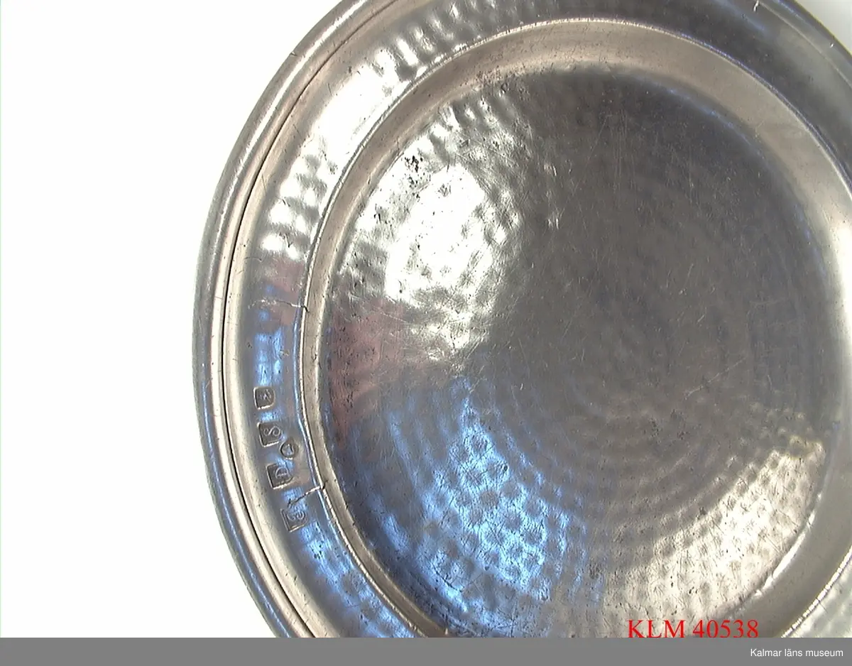 KLM 40538 Fat, tenn, runt. Stämplar på framsidan: I/J?, D, S, 0 samt en sköld med bila, krona och något mer. Stämplar på baksidan: Norrköping samt en sköld med krona (stämpel oläslig). Ristade initialer: IHS eller dylikt.