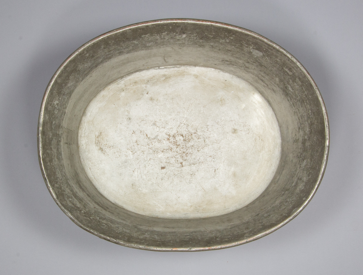Diskbalja av förtent kopparplåt, oval form. Vågräta handtag på kortsidorna, fästade med nitar. Baljan står på en fastlödd kant av stålplåt. På ett handtag märkt 13, på bottenkanten 40.