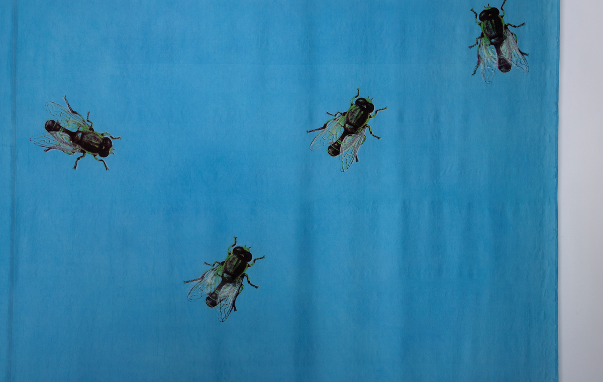 Tilnærmet kvadratisk tekstil i blå silke med trykk av fluer.