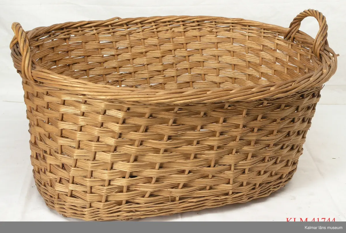 KLM 41744 Korg, 10 st, trä. Oval korg flätad av rotting på trästomme, två handtag i överkanten vid kortsidorna.
På några korgar hänger etiketter från Gamlebytvätten/Gamleby.
Några korgar är märkta med namnet Ruth Wimmerström.
Några korgar är märkta "Margarin".