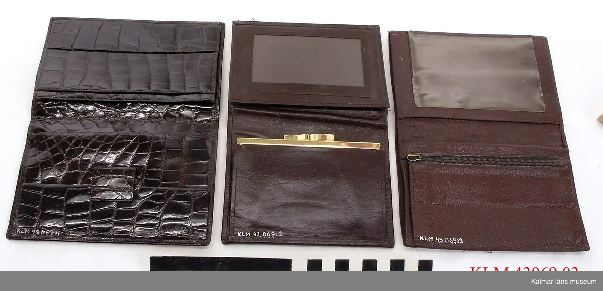 KLM 43069:3 Plånbok. Av brunt skinn. Myntfack med blixtlås.
Till höger på bilden.
