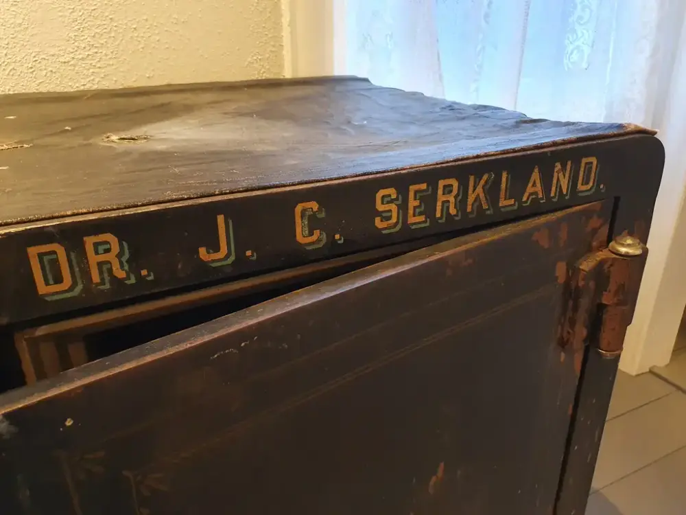 Nærbilde av safe, med namnet på Dr.J.C.Serkland preget øverst