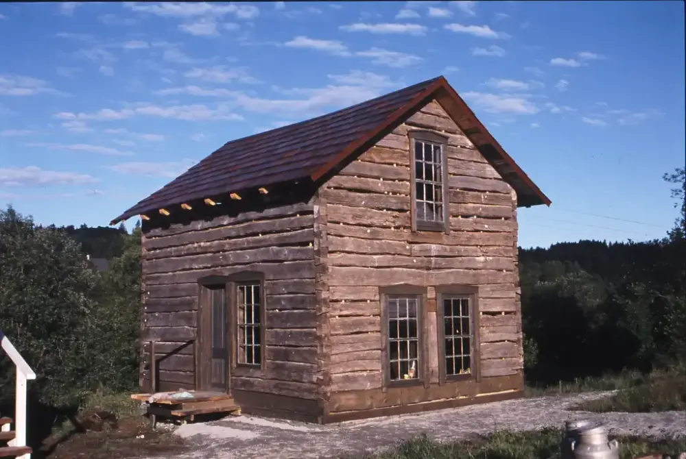 Tømmerbygning i to etasjar. Tre vindu i front og vindu og dør på langveggen