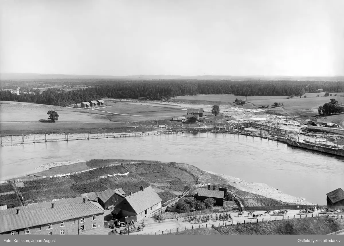 Tarris arbeiderbolig i østre del av Sarpsborg med omgivelser, i  bakgrunnen Grøtet-brua, 1899. I forgrunnen soldater på utmarsj under den store feltmanøveren i 1899.