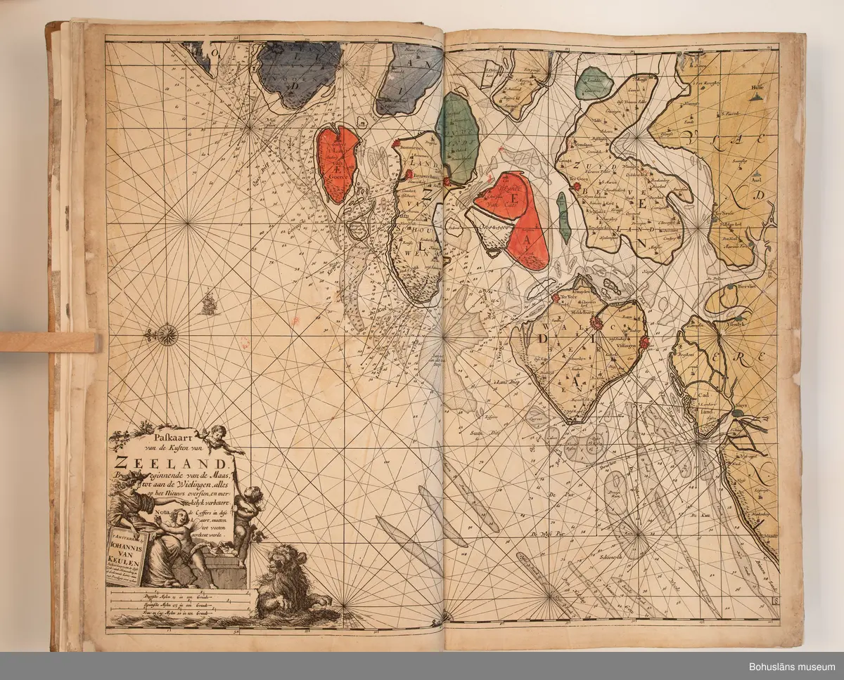 Holländskt sjökort i två sammanbundna delar, tryckta 1697 i Amsterdam.
Brunt skinnband av pergament i relativt gott skick med upphöjda bind. Text på nederlänska  i frakturstil med rikt illustrerade kartblad, ofta utvikbara. Restaurerad hos papperskonservator. 

Handanteckningar på pärmsidans insida:  
William Andrew Macfie 
Anfasteröd.
Till museum 14/9 64

Tryckt text på titelbladet första delen: 
De nieuwe groote lichtende zee-fackel, ´t derde deel. Verthoonende de kulten van Granada, Catalonien, Provence, Italien, Dalmatien, Grieken, Thracien, Anatolien, Syrien, Egypten, en de geheele noordkust van Barbaryen, met alle haer onderbehoorende en ... leggende eylanden. Als mede de beschrijvingh van alle havenen, bayen, reeden, drooghten, diepten, streckingen en opdoeningen van landen. Op de ware pools hoogte geleyd. Uyt ondervindinge van veel ervarene stuurlieden, lootsen en liefhebbers der zeevaert, vergadert door Claas Jansz. Vooght ... – 

T´Amsteldam, gedruckt by Joannes van Keulen, boeck-en zee-kaert-verkoper, aen de Nieuw-brugh, in de gekroonde lootsman, 1697, 1697 - 4], 29 s., s. 26, s. 31-92, s. 1-22, s. 1-20, [80] pl.-bl : kartor

Tryckt på titelbladet andra delen:
De nieuwe groote lichtende zee-fakkel, ´t tweede deel. Verthoonende de zee-kusten van het zyderste gedeelte van de Noord-zee, ´t Canaal, ´t westersche gedeelte van Engeland en Schotland, Yrland, Vrankrijk, Spanjen, Marocco, Gualata, Genehoa en Gambia, met de onder-vehoorige eylanden,mitsgaders ve vlaamsche, canarische en soute Eylanden. Als mede de ... van alle havenen, bayen, reeden, droogten, diepten, streckingen en opdoeningen van landen, op de ware pools hoogte geleyd, uptonderbindinge van veele ervarene stuurlieden, lootsen en lief-hebbers der zee-vaart. Zijnde van alle ... door Claes Jansz. Vooght ... - T´Amsterdam, gedrukt by Joannes van Keulen, boek zee-kaart-verkooper, en graadboogmaker aan de oost-zyde van de Nieuw-brug, in de gekroonde lootsman, 169.., 169n - 4], 4 s., s. 7-34, s. 53, s. 36, s. 35, s. 38, s. 35, s. 40-85, s. 68, s. 87-91, s. 29, s. 93-97, [87] pl.-bl : kartor