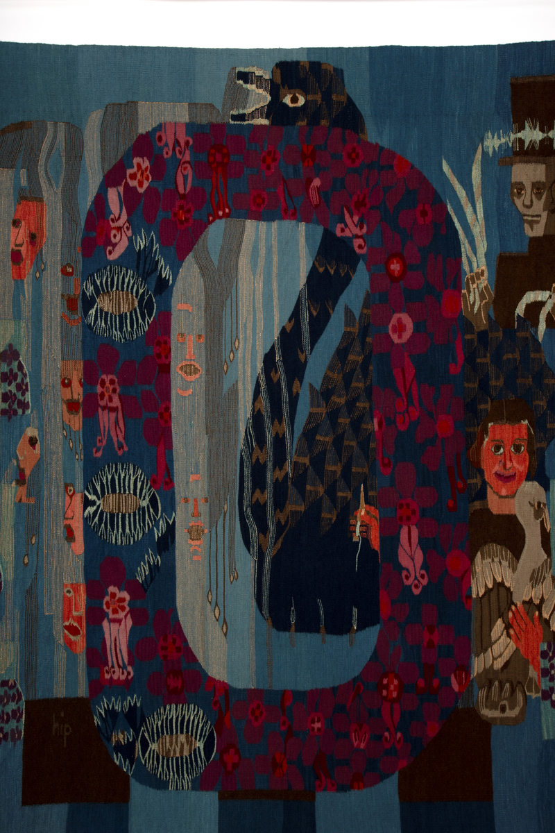 Ornamental figurkomposisjon som er bygd rundt en stor vertikal oval i midtre del. På hver side av ovalen, er menneskefigurer med diverse attributter omringet av blomsterornamentikk i flaten. Delvis overlappet av ovalformen er en mørkblå svane. Figuren til venstre har flosshatt og stokk, mens to av figurene til høyre har strykeinstrument og tråder i hendene. Den tredje halvfiguren på høyre side holder smilende ei gås i den ene armen og en vevnål i den andre hånden, som rekkes ut bak ovalen og stikker frem inni den. I tillegg er det ansiktsformer med åpne munner til venstre for og inni den ovale formen, inniblandt vertikale smale, bølgende striper. Hannah Ryggen har selv beskrevet og forklart motivet som en henvisningen til feiringen av Oslo bys 900-årsjubileum i 1950, da også Oslo Rådhus ble innviet. Hun fulgte selv arrangementet via radio, der hun hørte talene og skildringene av blant annet blomsterhjulet som var reist på Jernbanetorget. I sin tolkning lot hun det få form som en O for Oslo. Svanen viser til Dyra Vaas svaner i Rådhusets borggård. Ansiktsformene er en referanse til alle talerne, som til kunstnerens irritasjon bare var menn, og de fremstilles som en del av vannet som strømmer fra fontenene i Rådhuset. Figuren til venstre er Kong Haakon VII på vei nedover Karl Johans gate. Til høyre er arkitekten bak Rådhuset, Arnstein Arneberg, med stjerner i flosshatten, sammen med radioreporter Odd Hølaas med instrument. I et felt foran instrumentet er den første takten, altså de første fire tonene, av Norges nasjonalsang vevd inn. Halvfiguren med gåsa er et selvportrett.