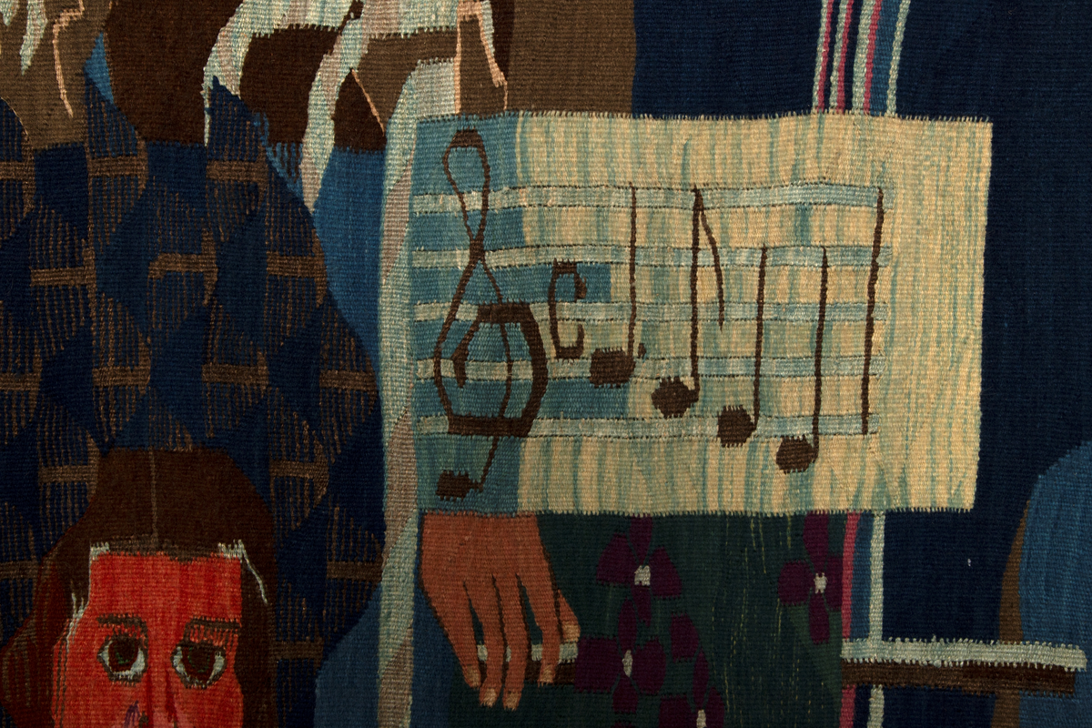 Ornamental figurkomposisjon som er bygd rundt en stor vertikal oval i midtre del. På hver side av ovalen, er menneskefigurer med diverse attributter omringet av blomsterornamentikk i flaten. Delvis overlappet av ovalformen er en mørkblå svane. Figuren til venstre har flosshatt og stokk, mens to av figurene til høyre har strykeinstrument og tråder i hendene. Den tredje halvfiguren på høyre side holder smilende ei gås i den ene armen og en vevnål i den andre hånden, som rekkes ut bak ovalen og stikker frem inni den. I tillegg er det ansiktsformer med åpne munner til venstre for og inni den ovale formen, inniblandt vertikale smale, bølgende striper. Hannah Ryggen har selv beskrevet og forklart motivet som en henvisningen til feiringen av Oslo bys 900-årsjubileum i 1950, da også Oslo Rådhus ble innviet. Hun fulgte selv arrangementet via radio, der hun hørte talene og skildringene av blant annet blomsterhjulet som var reist på Jernbanetorget. I sin tolkning lot hun det få form som en O for Oslo. Svanen viser til Dyra Vaas svaner i Rådhusets borggård. Ansiktsformene er en referanse til alle talerne, som til kunstnerens irritasjon bare var menn, og de fremstilles som en del av vannet som strømmer fra fontenene i Rådhuset. Figuren til venstre er Kong Haakon VII på vei nedover Karl Johans gate. Til høyre er arkitekten bak Rådhuset, Arnstein Arneberg, med stjerner i flosshatten, sammen med radioreporter Odd Hølaas med instrument. I et felt foran instrumentet er den første takten, altså de første fire tonene, av Norges nasjonalsang vevd inn. Halvfiguren med gåsa er et selvportrett.