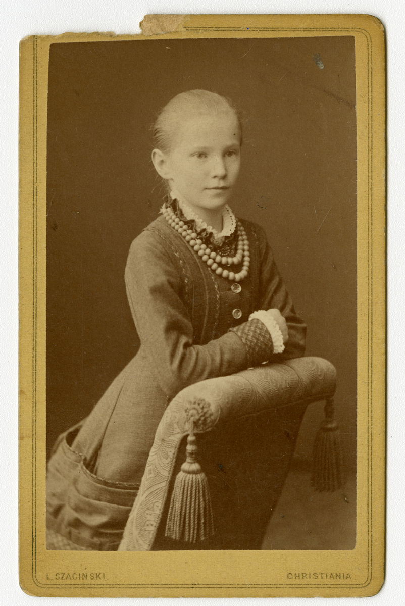 Portrett av ukjent jente, Houen slekt. Kan være Anne Kathrine Houen (f. 1871), datter av Nils Laurits Houen og Marie Eberhardt 

Påskrift: L. Szacinski. Christiania. 

Påskrift bak: K. Houen. 1882. L. Szacinski. Carljohansgade N4 ved stortorvet. Christiania. Eneberettighet.