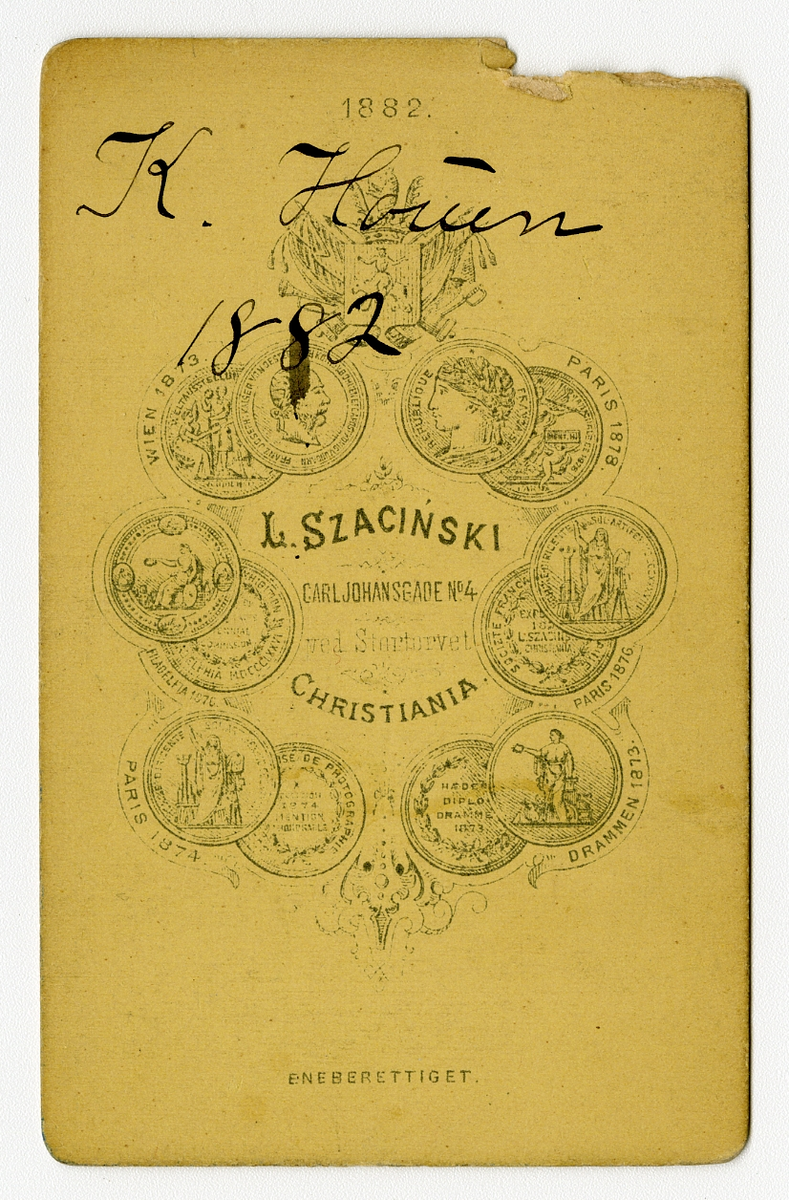 Portrett av ukjent jente, Houen slekt. Kan være Anne Kathrine Houen (f. 1871), datter av Nils Laurits Houen og Marie Eberhardt 

Påskrift: L. Szacinski. Christiania. 

Påskrift bak: K. Houen. 1882. L. Szacinski. Carljohansgade N4 ved stortorvet. Christiania. Eneberettighet.