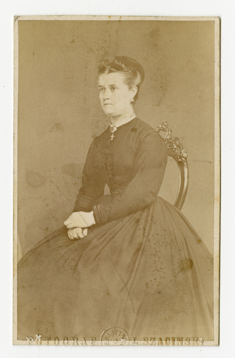 Portrett av kvinne. "M. Houen" i påskrift er antagelig Marie Houen (f. Eberhardt 1840)

Påskrift: Fotograf. L. Szacinski

Påskrift bak: Til Fru M. Houen Skien Fra L. Tommesen