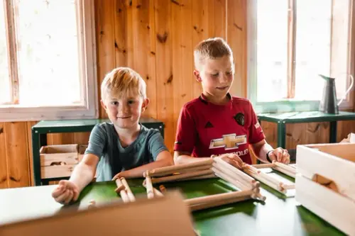 Barn bygger med laftestasjonen i Berganstua