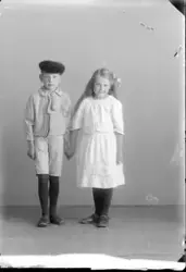 En liten pojke och flicka håller varandras hand, troligen sy