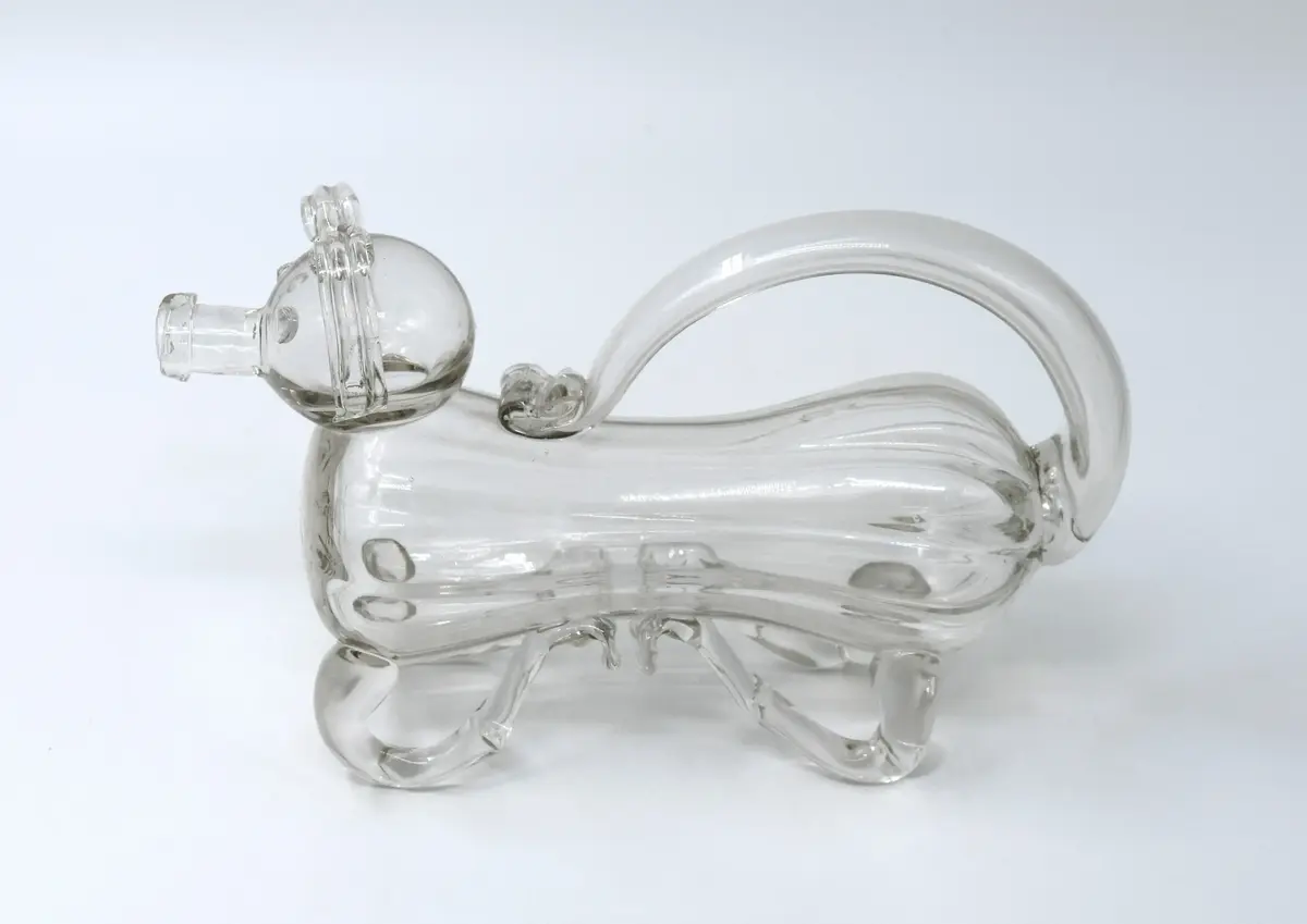 Kanna, "Fyllehund", av glas. I form av hund, påminnande om de medeltida aquamanilerna. 