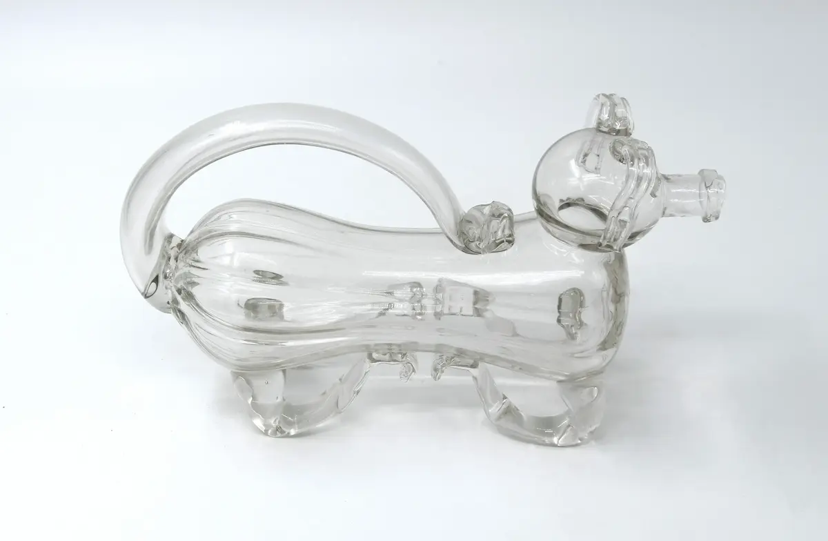 Kanna, "Fyllehund", av glas. I form av hund, påminnande om de medeltida aquamanilerna. 