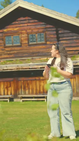 Ung kvinne på Solørtunet, på Glomdalsmuseet, som bruker appen Kulturpunkt