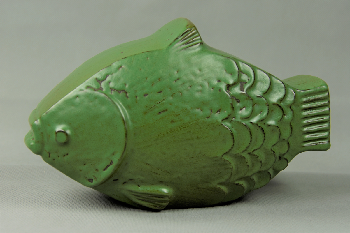 Hyonsun Rhee, skulptur, föreställande fisk, modellerat stengods i klargrön glasyr. Uppsala-Ekeby, 1910.

Klargrön keramisk fiskskulptur.
