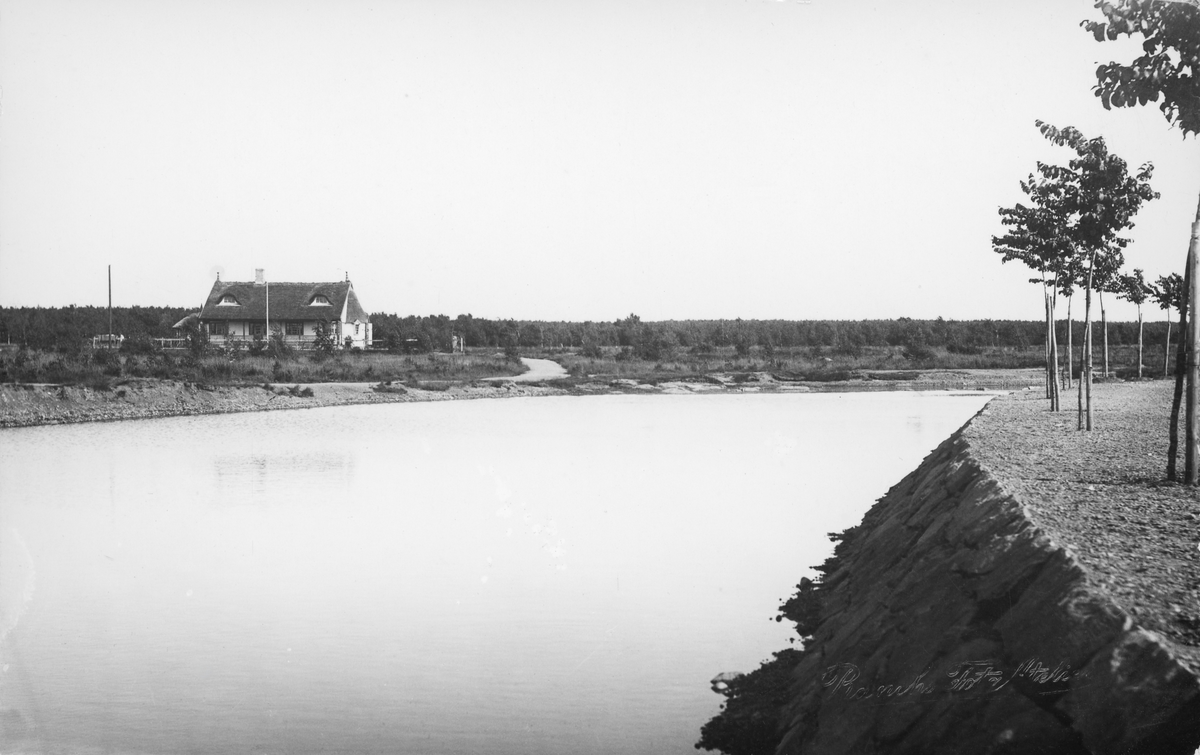 Vykort, "Varberg. Vy från Påskberget med Tivedstugan". Vattnet i förgrunden är Påskbergsdammen, mitt emot nuvarande Nöjesparken. Den såväl som stugan anlades 1906. Trädplanteringen var ännu ung och stugan har ljus fasad (mörk 1908) så troligen är fotografiet taget 1906-1908.
Bild 2: Utan text.