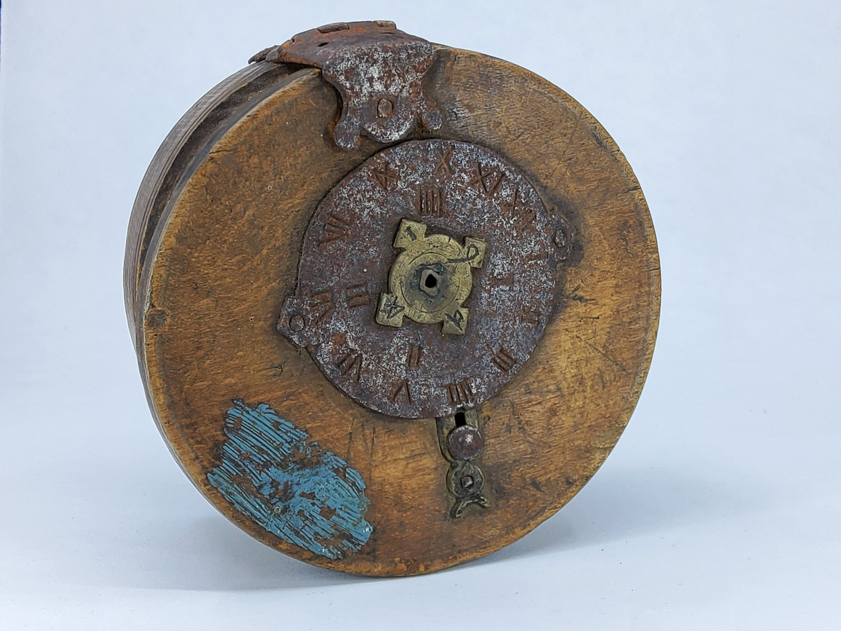 Stor, rund ask med plant lock, fäst med rikt utsirat gångjärn av järn. På lockets ovansida låstillbehör i form av urtavla av järn med mittdel av mässing. På lockets undersida låstillbehör av järn. Asken har fyra ristade dekorlinjer. Blå färgfläck på lockets ovansida. 
Pris: 5 kr.


Neg.nr: 1985-03
Sakord: ASK med lock
Tillverkningstid: 1750-1880
Material: björk järn mässing
Teknik: svarvat smitt spikat ristat
Mått: H=73  DIAM=150
Vikt: