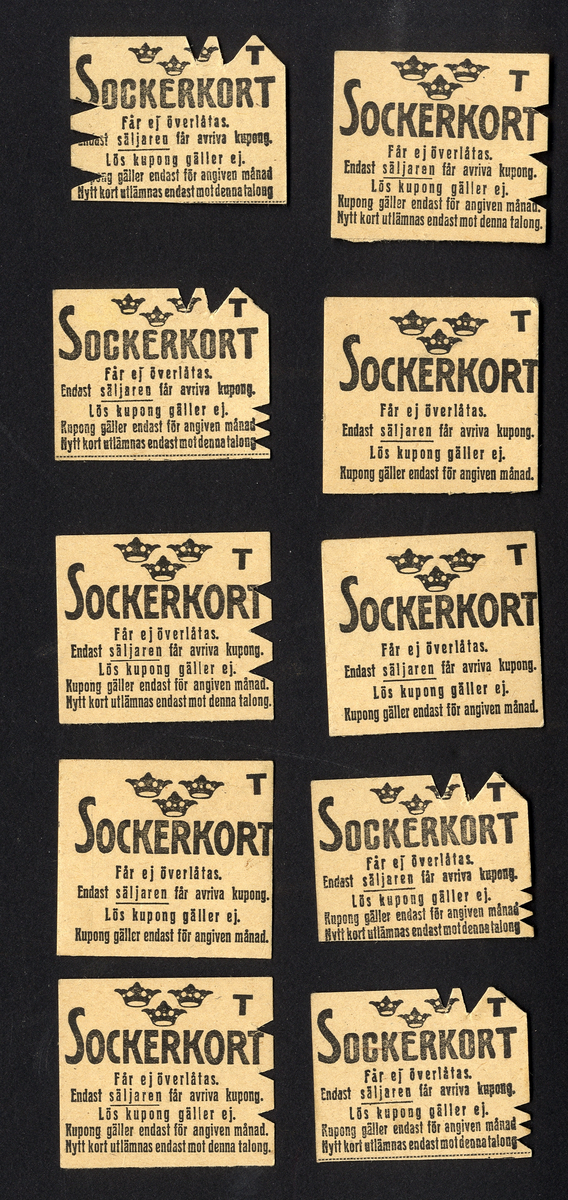 Förvaringsväska i papper för ransoneringskort (märkt "Växjö Mjölaffär 1914-1919" i blyerts).
Innehåller: 
Sockerkort (6 st. gröna, 10 st. svarta), sockerkort (syltsocker) 3 st., sockerkort (avlånga) 2 st..
Brödkort 5 st., Påbrödskort 5 st.. Kaffekort 2 + 3 st. Sirapskort 1.
