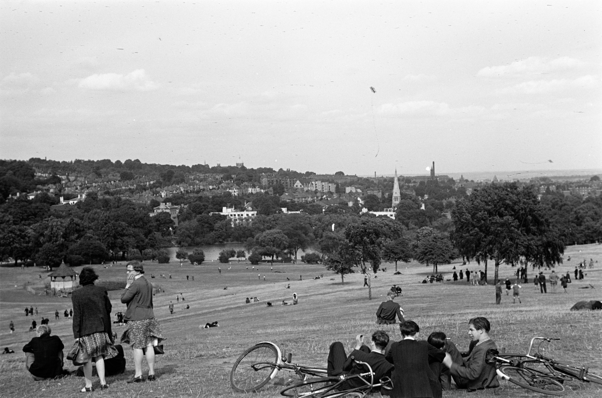 Folk i en park med utsikt til byen