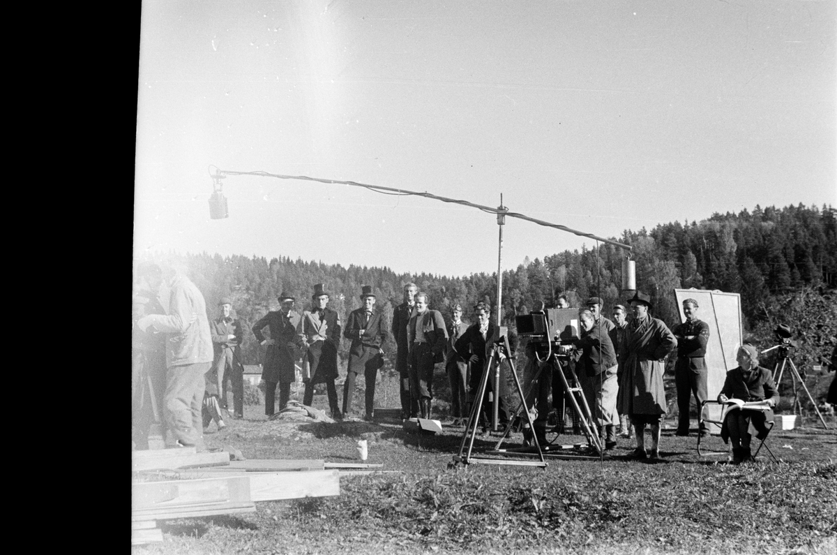 Filming og en stor gruppe folk i festantrekk