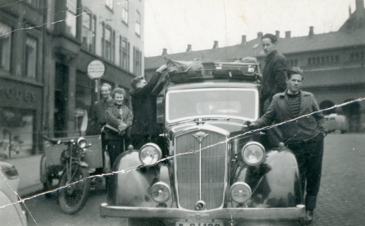 Frå v. Bjarne Løstegård. ukjent, Harald Hoftun, ukjent,  Ove Blakkestad, 
Før avreise frå Oslo på tur til Hallingdal. Domkirkebasarene i bakgrunnen. 
Bilen er ein Wolseley frå siste del av 30-tallet.