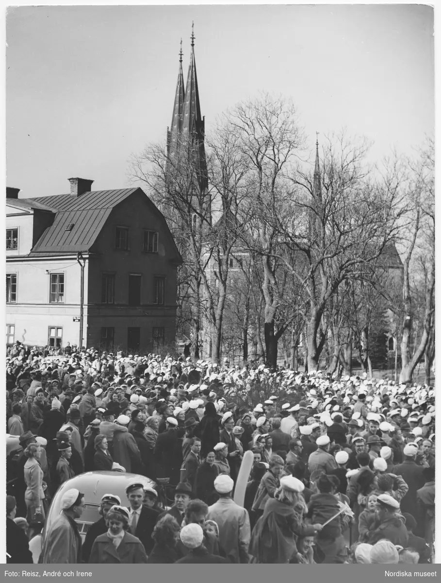 Valborgsmässoafton i Uppsala.  I samband med den traditonsenliga mösstpåtagningen kl 15.00 när studenterna på given signal rusar ner för Carolinabacken på Drottninggatan. Helga Trefaldighetskyrkan och Domkyrkan skymtar i bakgrunden.